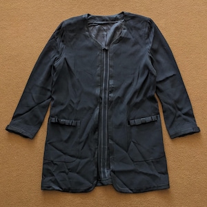 May include: A black long-sleeved jacket with a zipper closure and two pockets with decorative ruffles. The jacket has a v-neck and a satin lining.