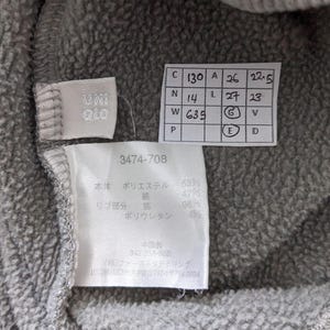 Puede incluir: Una etiqueta gris con texto y n&uacute;meros blancos. La etiqueta tiene el texto "3474-708" y la siguiente informaci&oacute;n: "Cuerpo: Poli&eacute;ster 53%, Algod&oacute;n 47%, Costilla: 96% Poliuretano 4%"