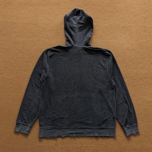 Op de afbeelding: Een donkergrijze hoodie met een rits. De hoodie is gemaakt van een zachte, textuurrijke stof.