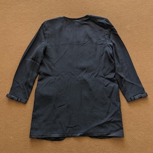 May include: A black long-sleeved blazer with a v-neck and a slightly flared hem.