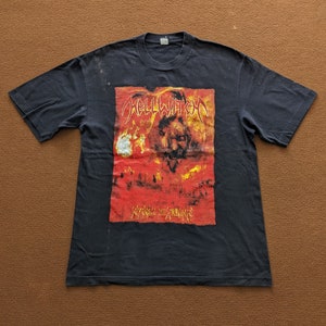 Puede incluir: Camiseta negra con un estampado gráfico de una banda llamada "Hellwaten" con el texto "Extreme in Extreme" debajo. El gráfico es una imagen roja y amarilla de una cara con llamas.