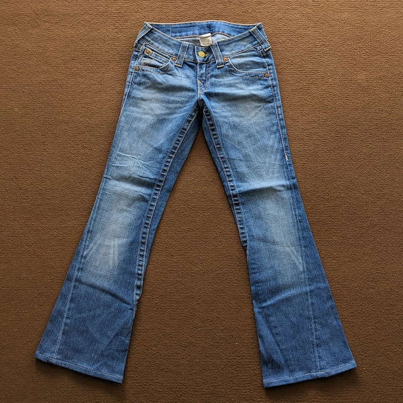 May include: A pair of blue denim jeans with a bootcut style. The jeans have a light wash and are made of a soft, comfortable fabric.