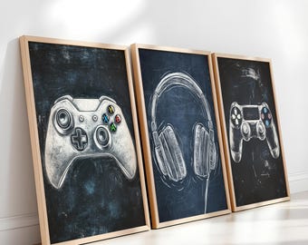May include: Three framed art prints with gaming illustrations. The prints depict a game controller, headphones, and another game controller, all in a sketch style with white outlines on a dark blue background. The frames are light brown, adding a neutral tone.