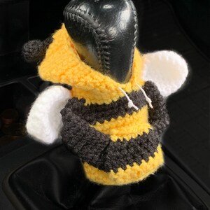 Puede incluir: Una funda de palanca de cambios de punto de ganchillo en forma de abeja, en amarillo, negro y blanco. La funda est&aacute; dise&ntilde;ada para adaptarse a una palanca de cambios est&aacute;ndar.