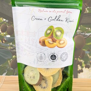 May include: A green resealable pouch containing dried fruit slices. The label features the text Nature in its purest form Green + Golden Kiwi, illustrations of whole and sliced kiwi fruit, and icons for Gluten Free, Non GMO, and No Added Sugar.