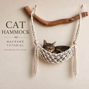 May include: A macramé cat hammock suspended from a curved wooden branch, featuring off-white knotted cord, two round wooden beads, and decorative fringe. A tabby cat rests inside the hammock. Text reads: CAT HAMMOCK MACRAMÉ TUTORIAL INTERMEDIATE LEVEL.