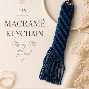 May include: A handmade macramé keychain in navy blue, featuring a woven design and a black metal clasp. The image includes text that reads "DIY Macramé Keychain Step by Step Tutorial". The keychain is displayed on a neutral background with floral accents.