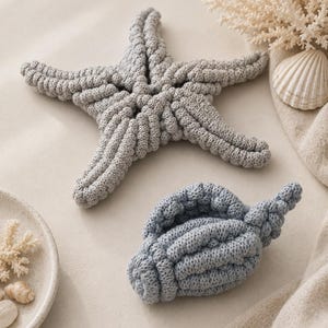 May include: A gray crocheted starfish and a blue crocheted seashell. The starfish has five textured arms and the seashell features a spiral shape. Both items are crafted with a visible knit pattern, showcasing a soft, tactile surface texture.