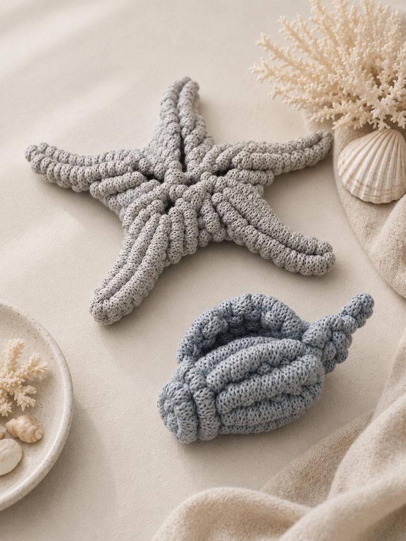 May include: A gray crocheted starfish and a blue crocheted seashell. The starfish has five textured arms and the seashell features a spiral shape. Both items are crafted with a visible knit pattern, showcasing a soft, tactile surface texture.