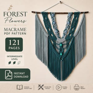 Puede incluir: Un tapiz de macramé con cordones en verde azulado oscuro y gris claro dispuestos en forma de V con cuentas azules y verdes, colgado de una rama de madera oscura. El texto incluye Forest Flowers Macrame PDF Pattern 121 Pages.