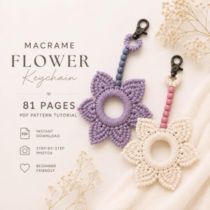 Op de afbeelding: Twee macramé bloem sleutelhangers, één lavendel en één crème, elk met een centrale ring, zes bloemblaadjes, een rij bijpassende houten kralen en een zwarte metalen karabijnhaak. Tekst: MACRAME FLOWER Keychain 81 PAGES PDF PATTERN TUTORIAL.
