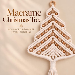 Puede incluir: Un adorno de pared de macramé con forma de árbol de Navidad, hecho de cuerda color crema con cuentas doradas, un anillo de madera en la parte superior y una borla en la base. Texto: Macrame Christmas Tree, ADVANCED BEGINNER LEVEL TUTORIAL.