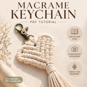 May include: A macrame keychain in the shape of a heart, with a bronze-colored clasp. The keychain is made of beige yarn and has a tassel at the bottom. Text on the image reads "MACRAME KEYCHAIN PDF TUTORIAL" and "INSTANT DOWNLOAD".