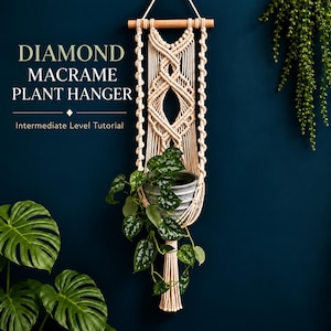 May include: A cream-colored macrame plant hanger featuring a diamond pattern, suspended from a wooden dowel. The text reads: DIAMOND MACRAME PLANT HANGER Intermediate Level Tutorial. A gray pot with a trailing green plant is held within the macrame.