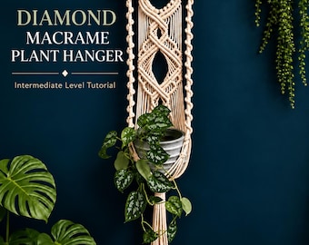 May include: A cream-colored macrame plant hanger featuring a diamond pattern, suspended from a wooden dowel. The text reads: DIAMOND MACRAME PLANT HANGER Intermediate Level Tutorial. A gray pot with a trailing green plant is held within the macrame.