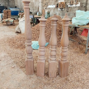 Puede incluir: Cuatro patas de mesa de madera sin terminar con un dise&ntilde;o torneado. Las patas est&aacute;n de pie sobre una superficie cubierta de virutas de madera.