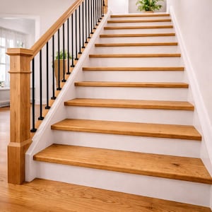 May include: A wooden staircase with light brown steps and white risers. The staircase has a wooden handrail and black iron balusters. A potted plant sits on the landing. The flooring is light brown wood.