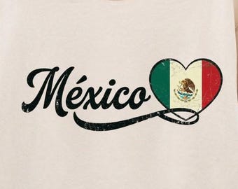 May include: A cream-colored crewneck sweatshirt featuring the word México in black cursive script. To the right of the text is a heart-shaped graphic filled with the green, white, and red colors of the Mexican flag, including the central emblem.