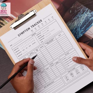 May include: A white paper symptom tracker form with black text and lines, secured on a light brown wooden clipboard. The form includes sections for date, energy level, stress, sleep, temperature, heart rate, blood pressure, and daily notes.