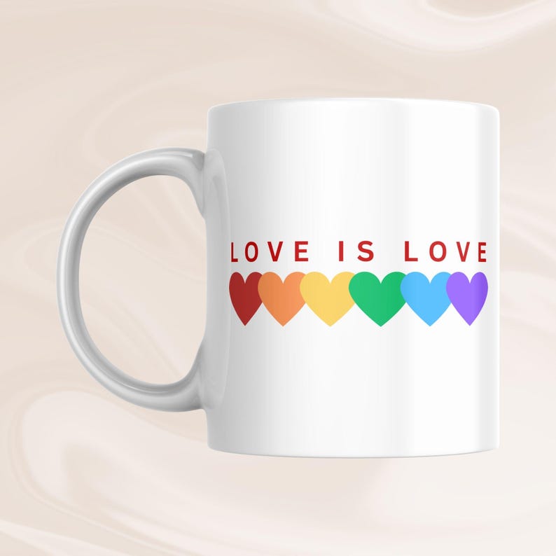 May include: White ceramic mug with the text "LOVE IS LOVE" in red. Below the text are six colorful hearts in a rainbow pattern. The mug has a curved handle on the left side.