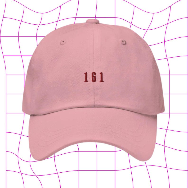 May include: A pink baseball cap with the number "161" embroidered in red on the front.
