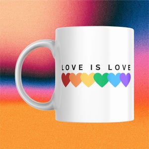 May include: White ceramic mug with the text "LOVE IS LOVE" and a row of six colorful hearts in rainbow colors. The mug has a curved handle and is set against a colorful gradient background.