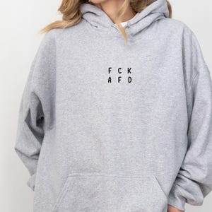 May include: A gray hooded sweatshirt with the text "FCK AFD" printed on the front.