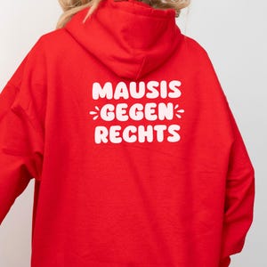 May include: Red hooded sweatshirt with the text "MAUSIS GEGEN RECHTS" in white.