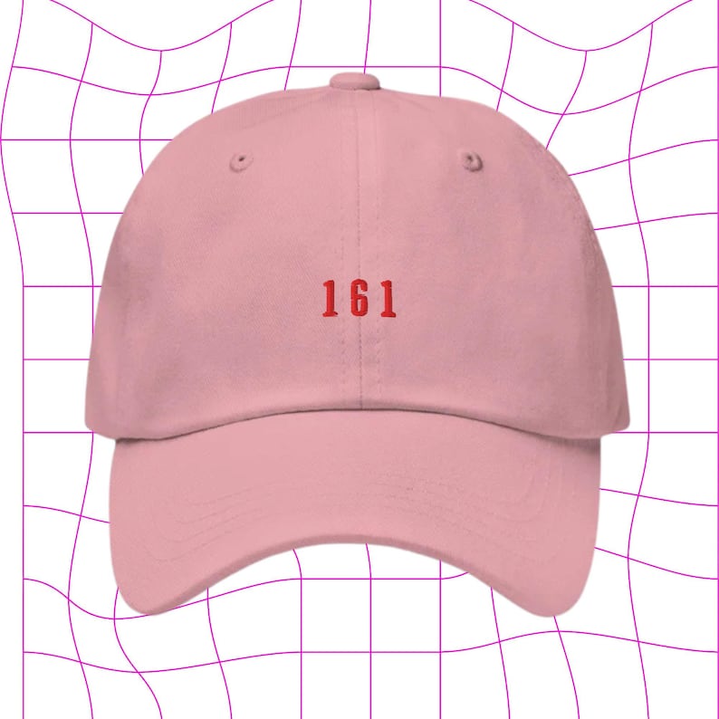 May include: A pink baseball cap with the number 161 embroidered in red on the front.