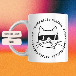 Op de afbeelding: Witte keramische mok met een zwart-witte illustratie van een kat met een zonnebril en een sigaret. De tekst rond de kat luidt "Katzen gegen Glatzen. Katzen gegen Glatzen."