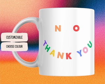 Può includere: Tazza in ceramica bianca con un design "NO THANK YOU" arcobaleno. Le lettere sono disposte a forma di faccina sorridente.