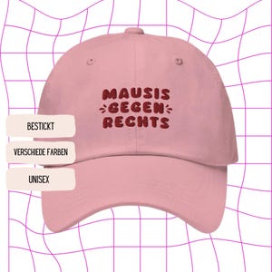 Può includere: Cappellino da baseball rosa con il testo "MAUSIS GEGEN RECHTS" ricamato in rosso.