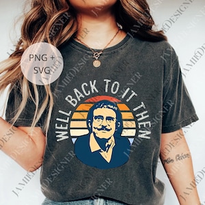 May include: Dark gray t-shirt featuring a retro design with the text "WELL BACK TO IT THEN" around a portrait of a man with glasses and a mustache. The design includes orange, yellow, and blue colors.