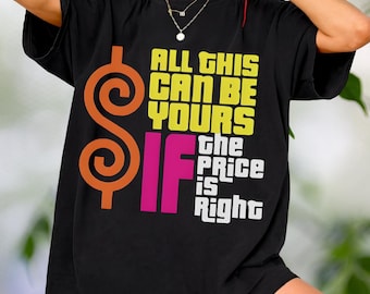 Puede incluir: Camiseta negra con el texto "ALL THIS CAN BE YOURS IF The PRICE IS Right" en amarillo, blanco y rosa. El diseño incluye un signo de dólar naranja. La camiseta es de estilo casual y oversize.