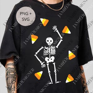 Könnte beinhalten: Schwarzes T-Shirt mit einem weißen Skelett, das mit Candy Corn jongliert. Das Design enthält den Text "PNG + SVG" in einem Kreis. Oben ist eine goldene Kette zu sehen. Ideal für Halloween.