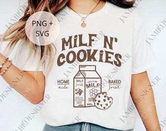 May include: A white t-shirt with the text "MILF N' COOKIES" in brown lettering. Below the text is a graphic of a milk carton and a cookie. The shirt also has the text "HOME made", "MILF fresh", and "BAKED fresh".