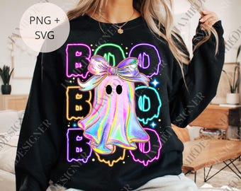 May include: Black sweatshirt featuring a colorful ghost design with the word "BOO" in neon-style lettering. The ghost has a large bow and the design includes stars. The image also includes the text "PNG + SVG".