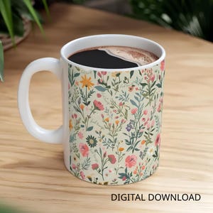 May include: A white ceramic mug filled with dark coffee, adorned with a floral design of pink, yellow, and blue flowers on a cream backdrop. The mug has a white handle and the words "Digital Download" are at the bottom.