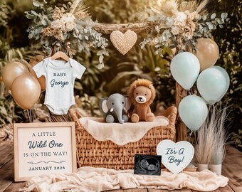 Peut inclure: Une scène d'annonce de bébé avec un body blanc qui dit "BABY George". Une pancarte indique "A LITTLE Wild One IS ON THE WAY! JANUARY 2026". Comprend un lion et un éléphant en peluche, des ballons et une pancarte "It's A Boy!"