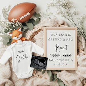 Puede incluir: Anuncio de bebé con un body blanco con la inscripción "Baby Smith", un letrero enmarcado que dice "Our Team Is Getting A New Recruit Taking The Field July 2025", un balón de fútbol, un peluche de zorro y una imagen de ultrasonido.