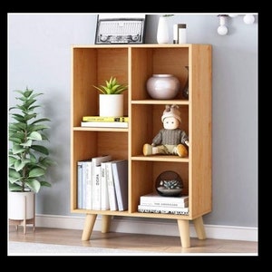 #WoodenShelf #OpenBookcase #3TierDisplay #FreestandingCabinet #RackwithLegs #MultipleCubes #FreeStandingBookshelf #HousewarmingGift #HomeDecor #ModernFurniture #StorageSolution #OrganizedLiving #InteriorDesign #MinimalistStyle #NaturalWood