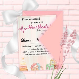 May include: A pink invitation with the text "From whispered prayers to Heartbeats!" and the names "Eliana &" is displayed. The invitation includes the date "July 23" and RSVP information. The invitation is decorated with watercolor illustrations of baby toys.