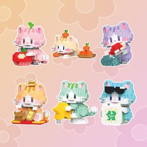 May include: Six colorful cat-shaped building blocks, each with a different design and expression. The cats are wearing hats and holding various objects, including a red fish, a green leaf, and a yellow flower. The blocks are made of plastic and are suitable for children ages 3 and up.