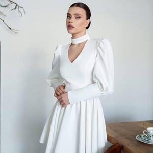 Minivestido blanco lechoso con mangas largas abullonadas y escote en V para una despedida de soltera o una fiesta de compromiso.