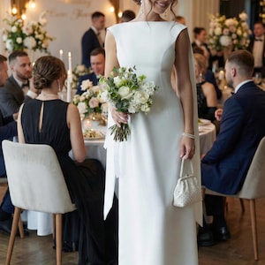Vestido longo de noiva branco leite com decote canoa e costas abertas profundas em crepe diagonal premium.