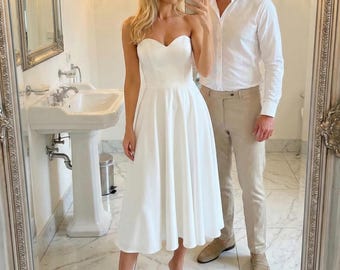 Witte schalingsjurk: strapless gerechtsgebouwtrouwjurk