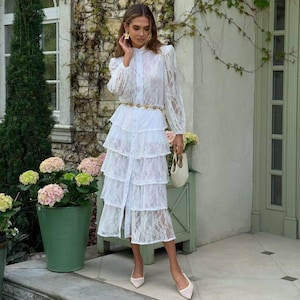 Vestido de novia romántico de encaje blanco leche con capas de guipur, mangas largas y forro de pantalón corto incluido para ocasiones especiales.
