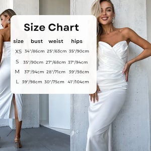 K&ouml;nnte beinhalten: Ein wei&szlig;es tr&auml;gerloses Satinkleid mit hohem Schlitz. Das Bild enth&auml;lt eine Gr&ouml;&szlig;entabelle mit Ma&szlig;en in cm f&uuml;r Brust, Taille und H&uuml;fte. Der Text "Size Chart" steht oben.