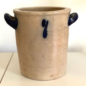 Könnte beinhalten: Ein weißer Keramiktopf mit blau bemalten Griffen und einer blauen Nummer "9" auf der Vorderseite.