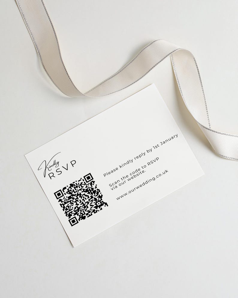 Puede incluir: Una tarjeta RSVP rectangular blanca con texto negro que dice Kindly RSVP, Please kindly reply by 1st January, Scan the code to RSVP via our website y www.ourwedding.co.uk, junto a un c&oacute;digo QR negro y una cinta con borde plateado.
